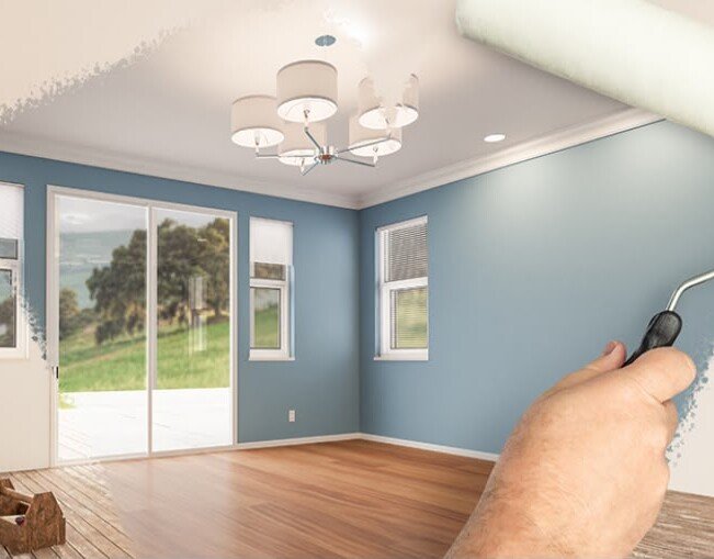 Roller repainting a wall and ceiling blue, before-and-after view of a living room